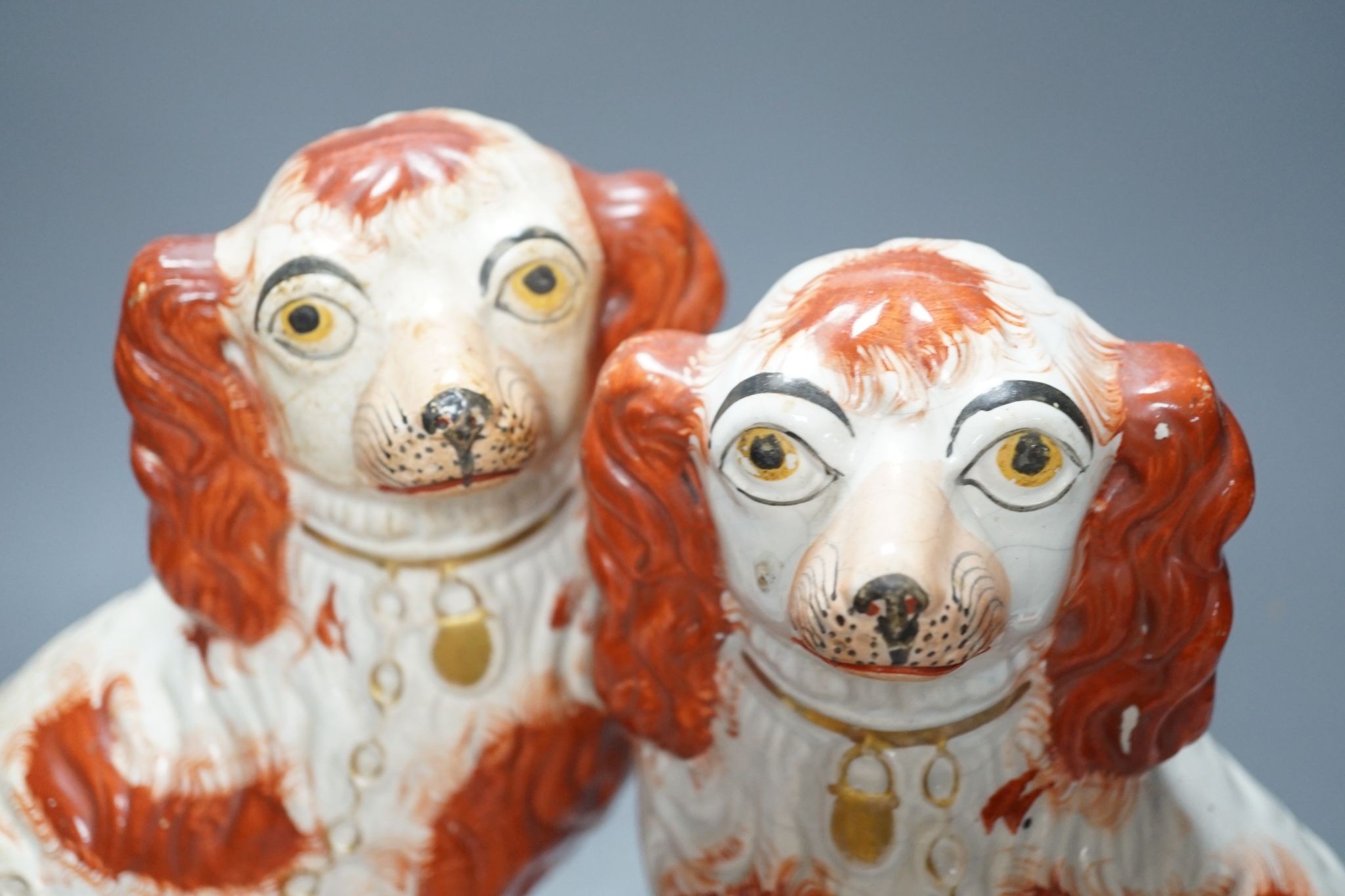 A pair of Victorian Staffordshire Spaniel chimney dogs and a greyhound, chimney dogs 31 cms high.